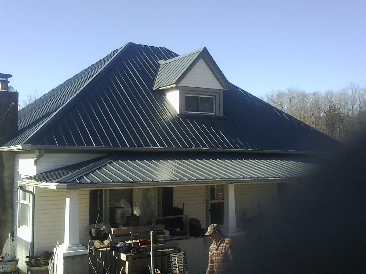 Dark blue standing seam metal roof with a dormer above a front porch in Perry Hall