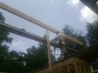 Carpenter setting a ridge beam over a new addition frame — Ice Dam Removal by Roofing Brothers in Perry Hall