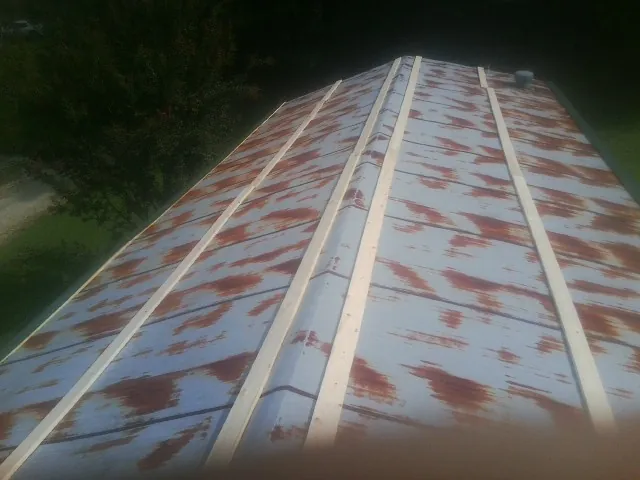 Rusted metal roof panels with new wood purlins before replacement — Storm Damage Roof Repair in Perry Hall by Roofing Brothers