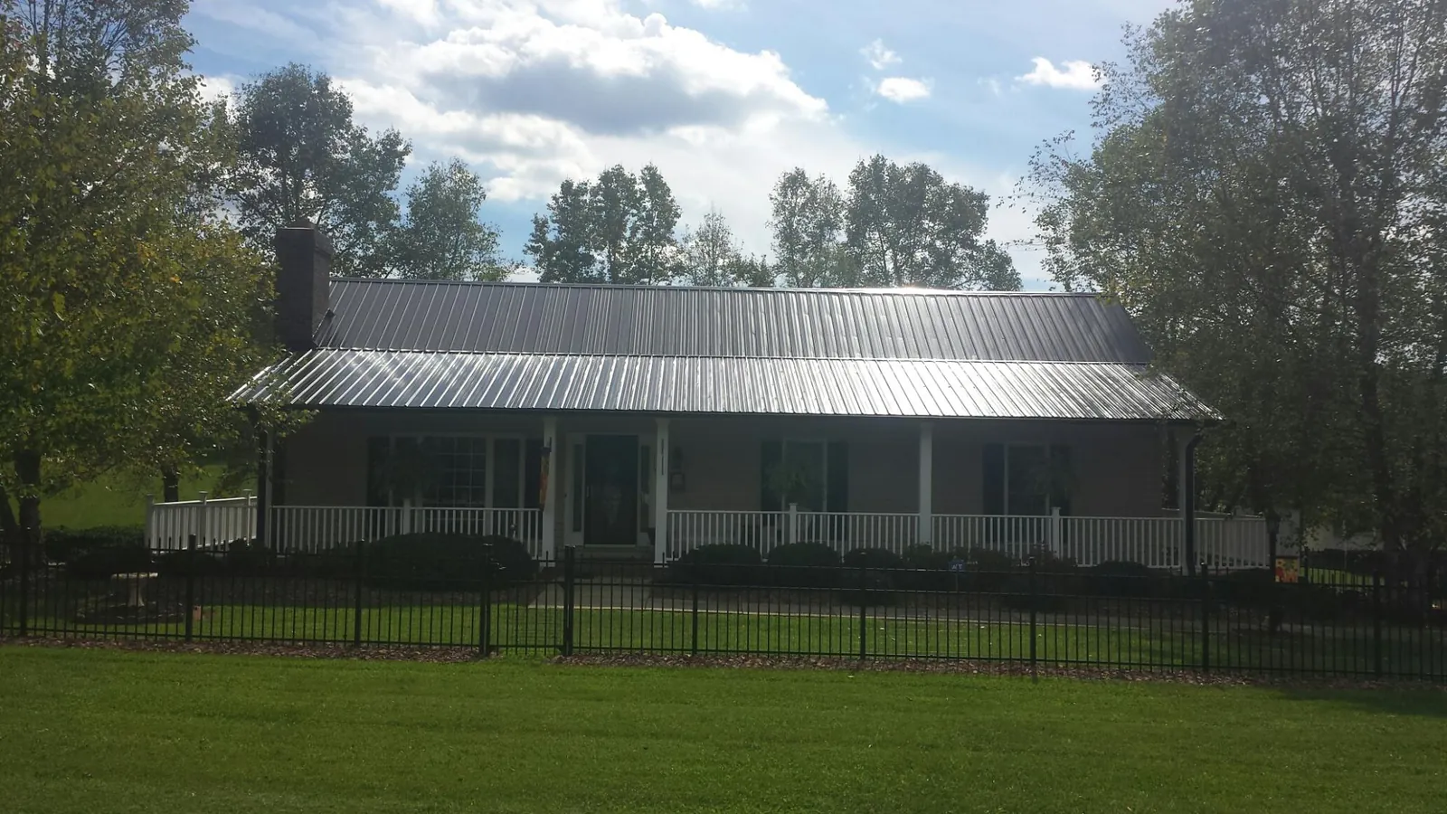 Gray metal roof on a brick ranch with a full width front porch — Gutter Guard Installation work by our crew in Perry Hall