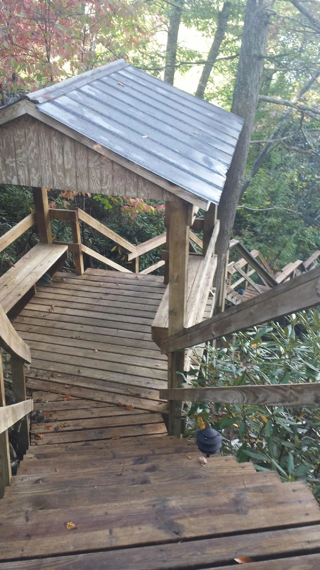 Metal roofed shelter over wooden steps on a wooded walkway — Skylight Repair & Installation work by our crew in Perry Hall