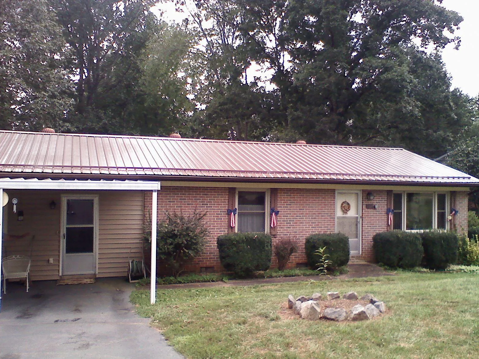 Bronze metal roof and carport on a brick ranch home — Roof Repair work by our crew in Perry Hall